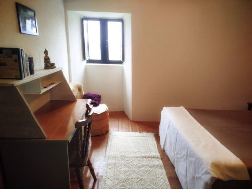 Habitación acogedora con escritorio, silla, cama y ventana luminosa.